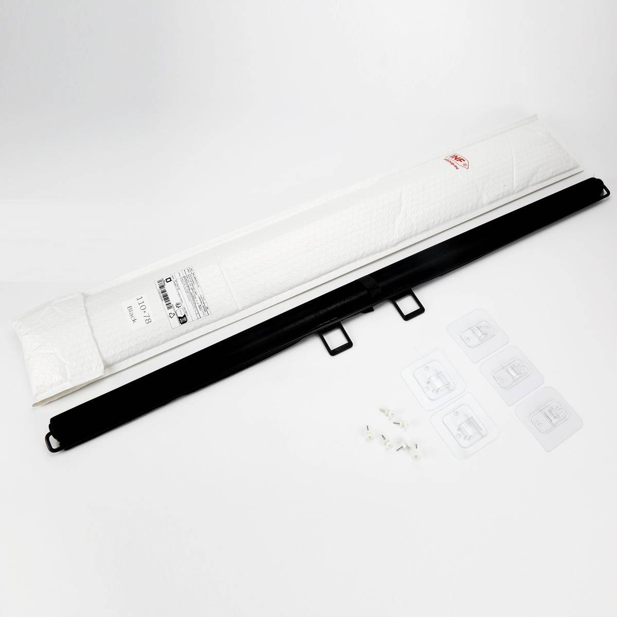 Weiße verpackte Hülle mit schwarzem Riemen oder Etui diagonal auf schlicht weißem Untergrund angeordnet, mit kleinen Anweisungsetiketten und Kunststoffzubehörteilen in der Nähe.