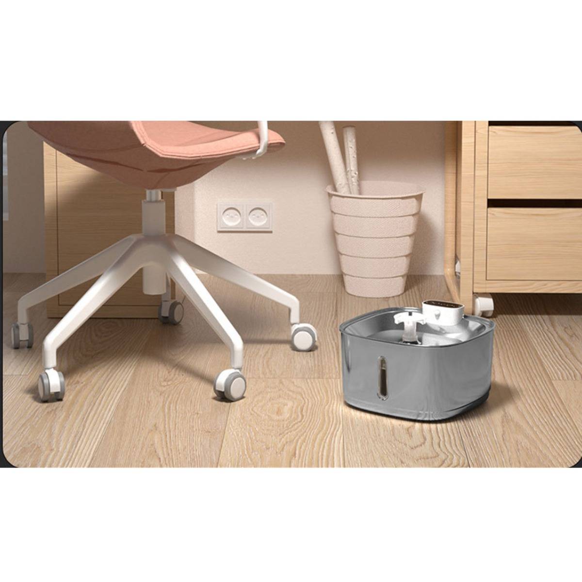 Grauer Roboterstaubsauger auf einem Holzboden neben einem rosa Bürostuhl und Schreibtisch, mit einem weißen Blumentopf im Hintergrund.