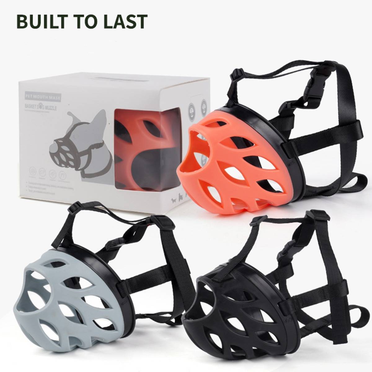 Drei Maulkörbe für Hunde in Schwarz, Orange und Grau, dargestellt neben einer Verpackung mit dem Text „BUILT TO LAST