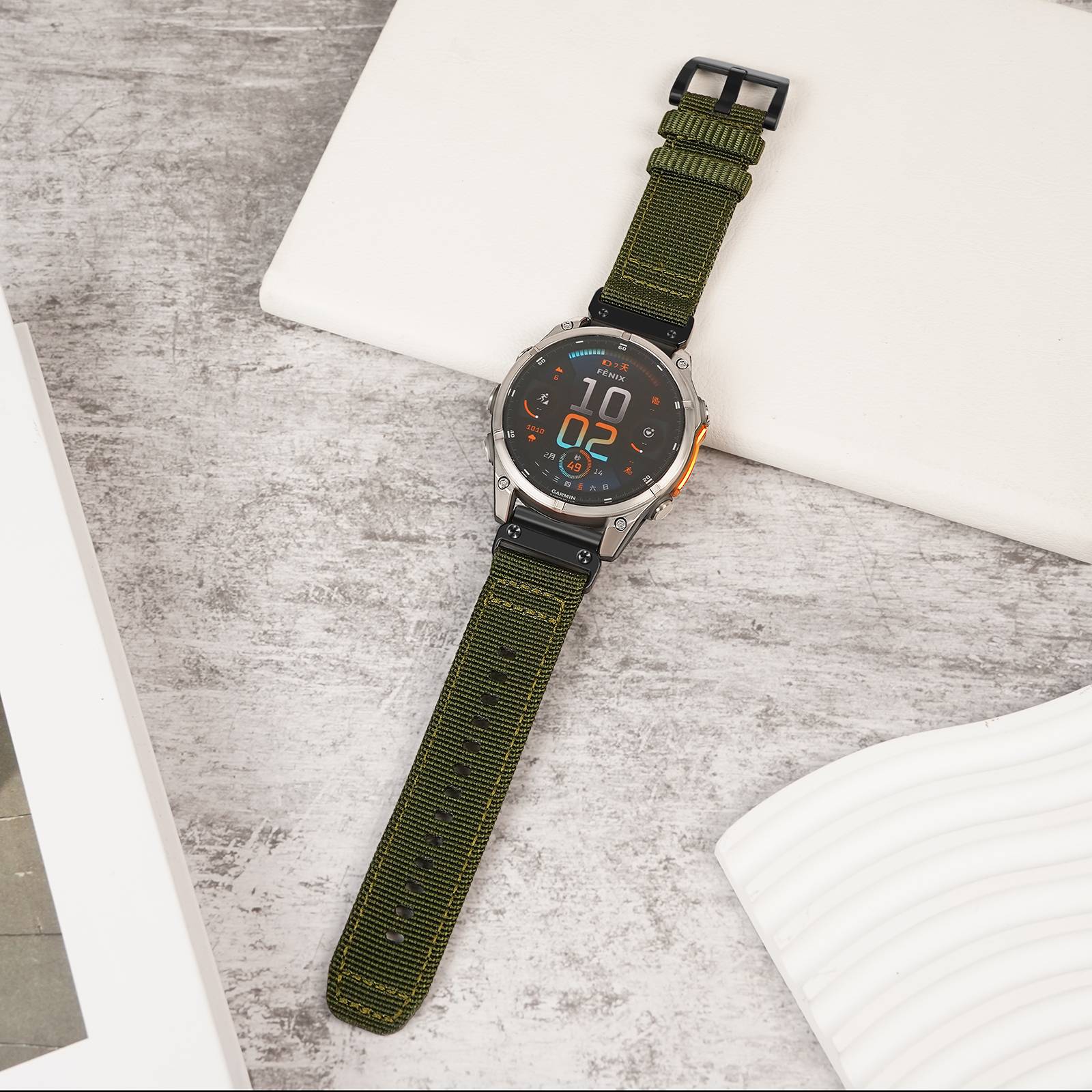Grüne-Riemen digitale Armbanduhr mit rundem schwarzem Zifferblatt liegt diagonal auf einer hellgrauen Oberfläche.