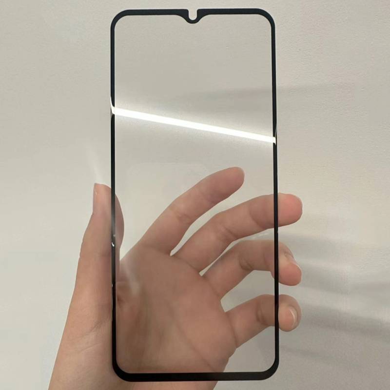 Hand, die einen durchsichtigen Displayschutz für ein Smartphone mit schwarzem Rahmen und oberer Kerbe gegen einen einfarbigen Hintergrund hält.