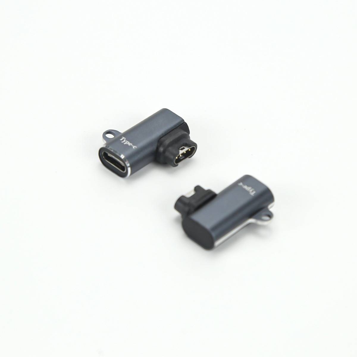 Zwei kleine dunkelgraue USB-C-Adapter-Dongles auf weißem Hintergrund, separat angezeigt, um ihre Steckerenden zu zeigen.