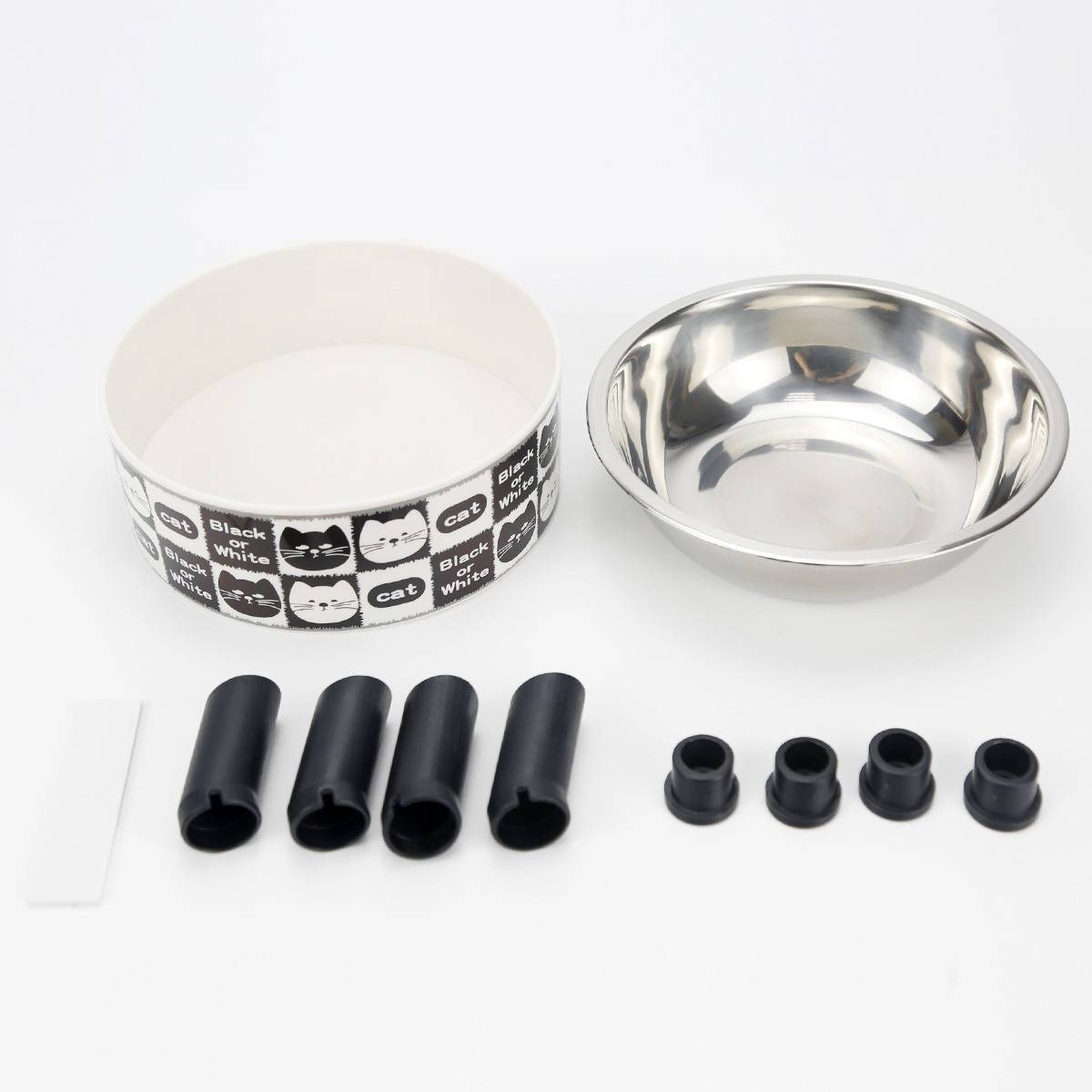Haustierfutter-Set mit einer Schüssel aus Edelstahl, einem gemusterten Futterkanister, vier schwarzen Gummifüßen, vier kleinen Kappen und einem weißen Spatel oder Schaber.