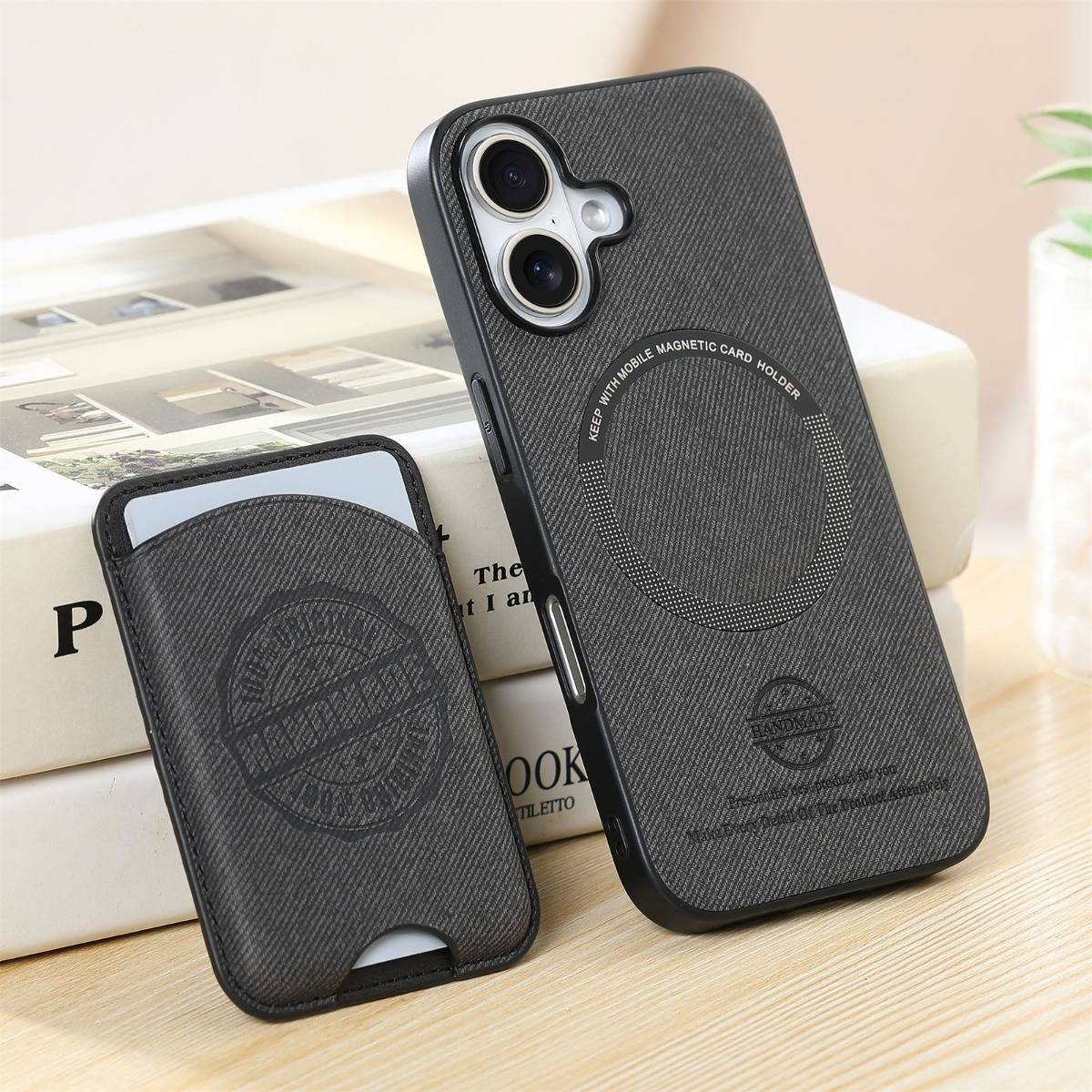 Schwarze strukturierte magnetische Handyhülle und passendes Kartenhalterwallet auf einem Tisch gezeigt, mit kreisförmigen MagSafe-ähnlichen Ausrichtungsmarkierungen.
