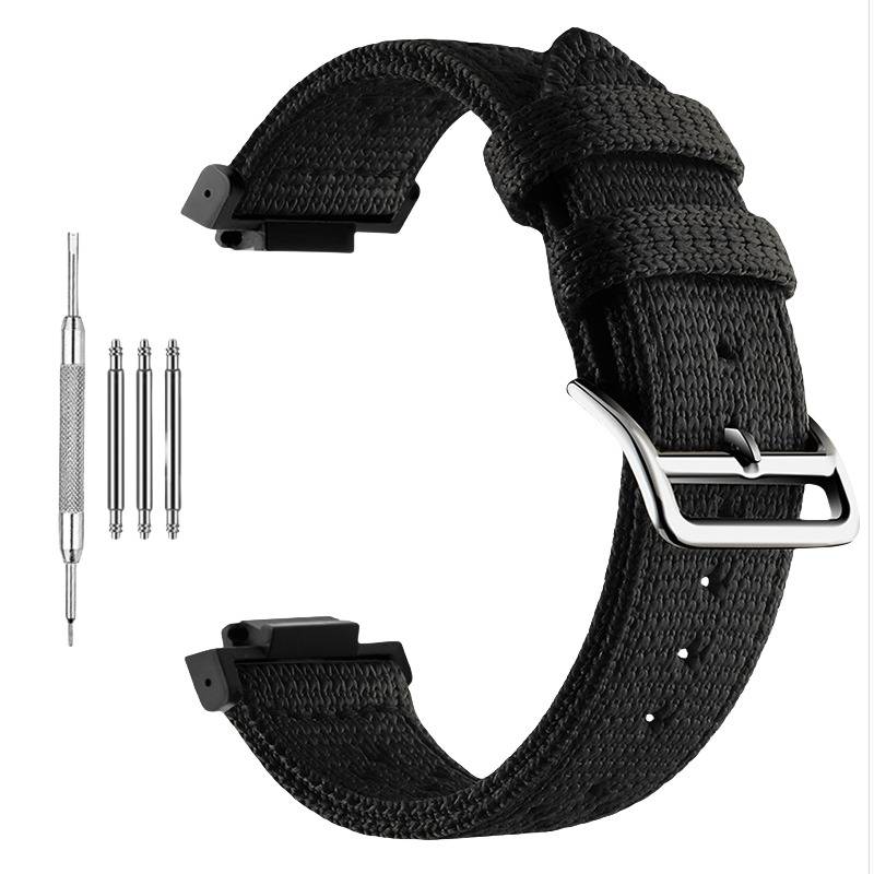 Schwarzes gewebtes Uhrenarmband mit silberner Schnalle, abgebildet mit vier mitgelieferten Metallfedern-Stegwerkzeugen/Teilen auf weißem Hintergrund.