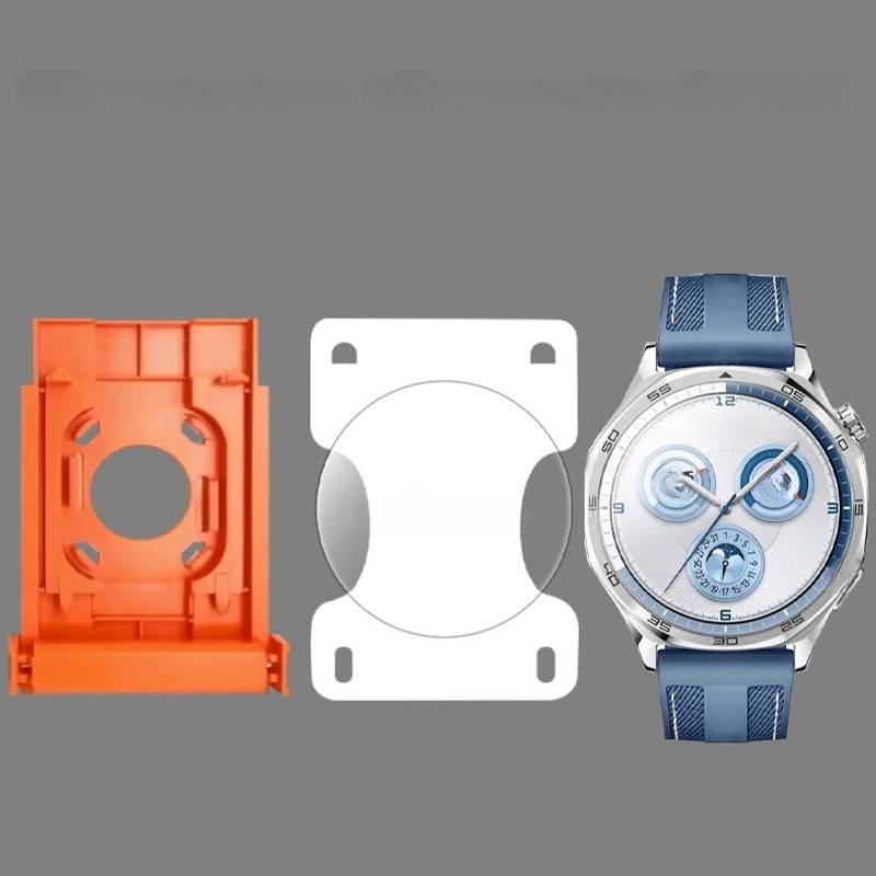 Drei Uhrenteile auf grauem Hintergrund: eine orange Kunststoffhalterung, eine weiße Montageplatte und eine blaue Armbanduhr mit rundem Zifferblatt und blauem Armband.