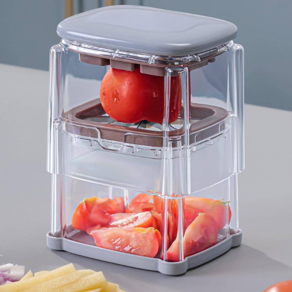 Transparenter Küchenreibe schneidet Tomaten in Würfel, wobei gehackte Stücke im unteren Behälter gesammelt werden und eine ganze Tomate oben eingelegt ist.