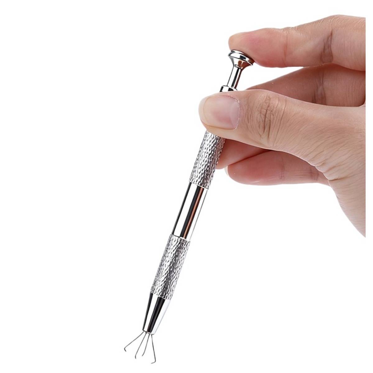 Hand, die einen federbelasteten Metallkopfhautmassager mit vier Drahtspitzen auf weißem Hintergrund hält.