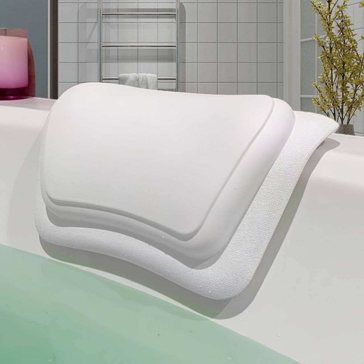 Gestapelte weiße ergonomische Schaumstoffkissen oder Kissen, die auf der Badewannenkante in einem Badezimmer-Ausstellungsraum ausgestellt sind.