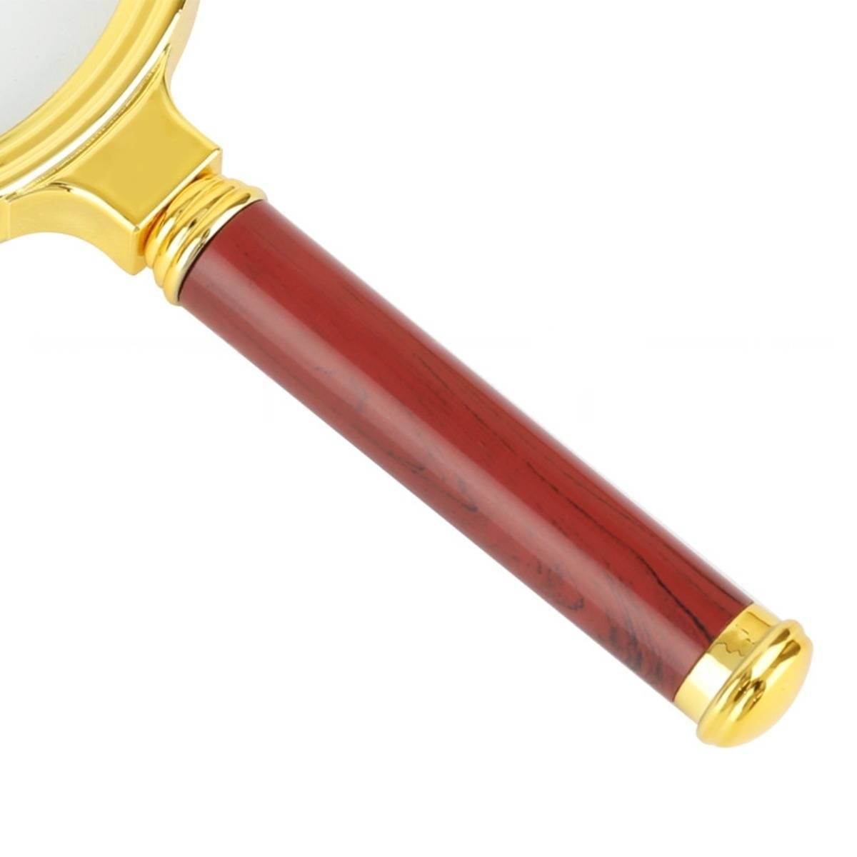 Nahaufnahme einer gold- und rotfarbenen tragbaren Lupe mit einem Griff im Holzstil auf weißem Hintergrund.