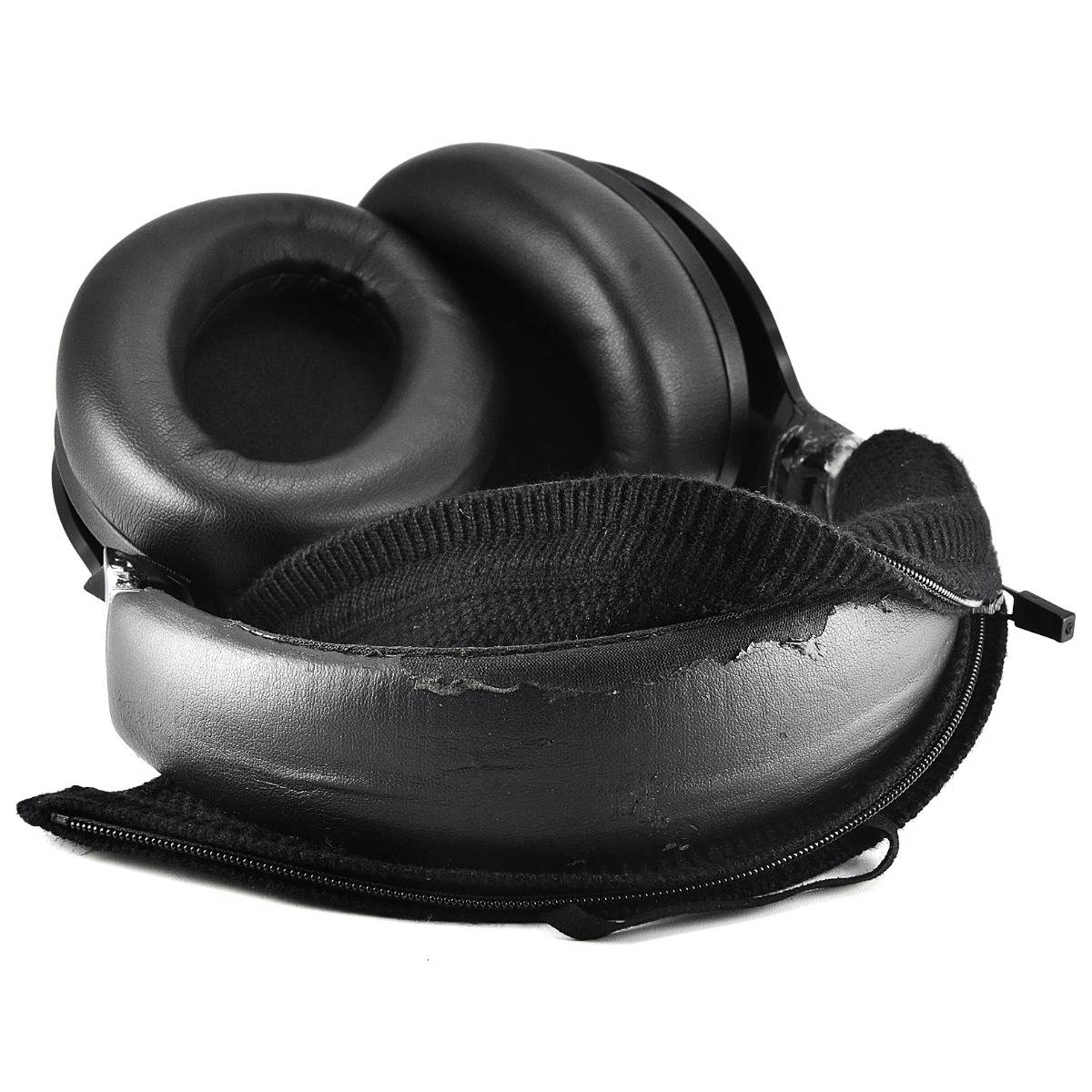 Schwarze Over-Ear-Kopfhörer mit gepolsterten Ohrmuscheln und einer aufgeklappten Reißverschluss-Hartschalenbox auf weißem Hintergrund.