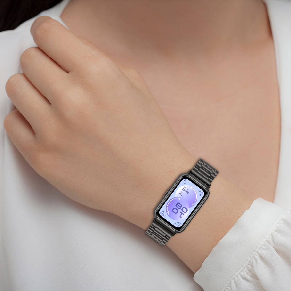 Nahaufnahme einer Person, die eine schlanke rechteckige Smartwatch mit violettem digitalen Display auf einem Metallband trägt.