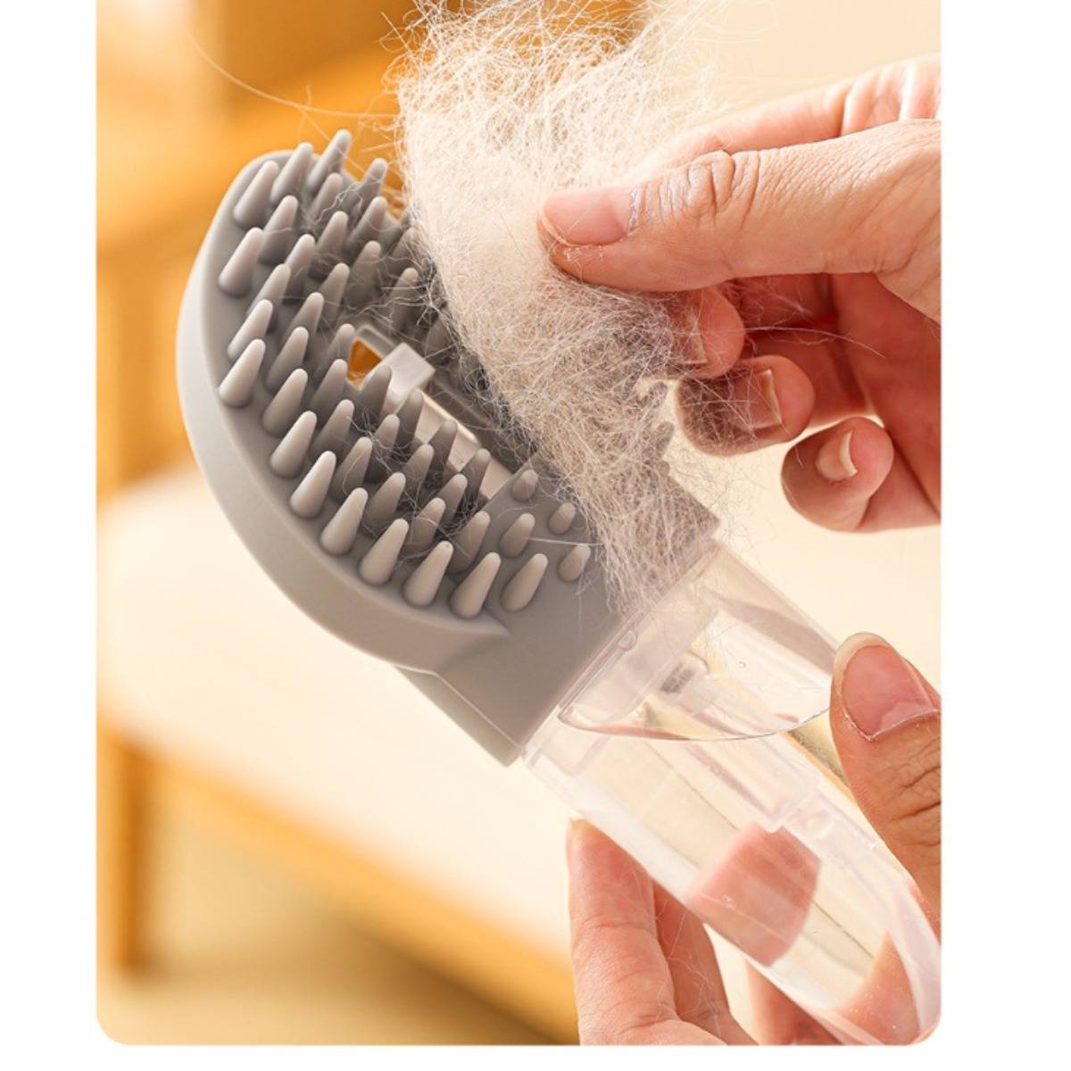 Hände reinigen Flusen aus einer grauen Tierhaar-Entfernungsbürste mit transparentem Griff.