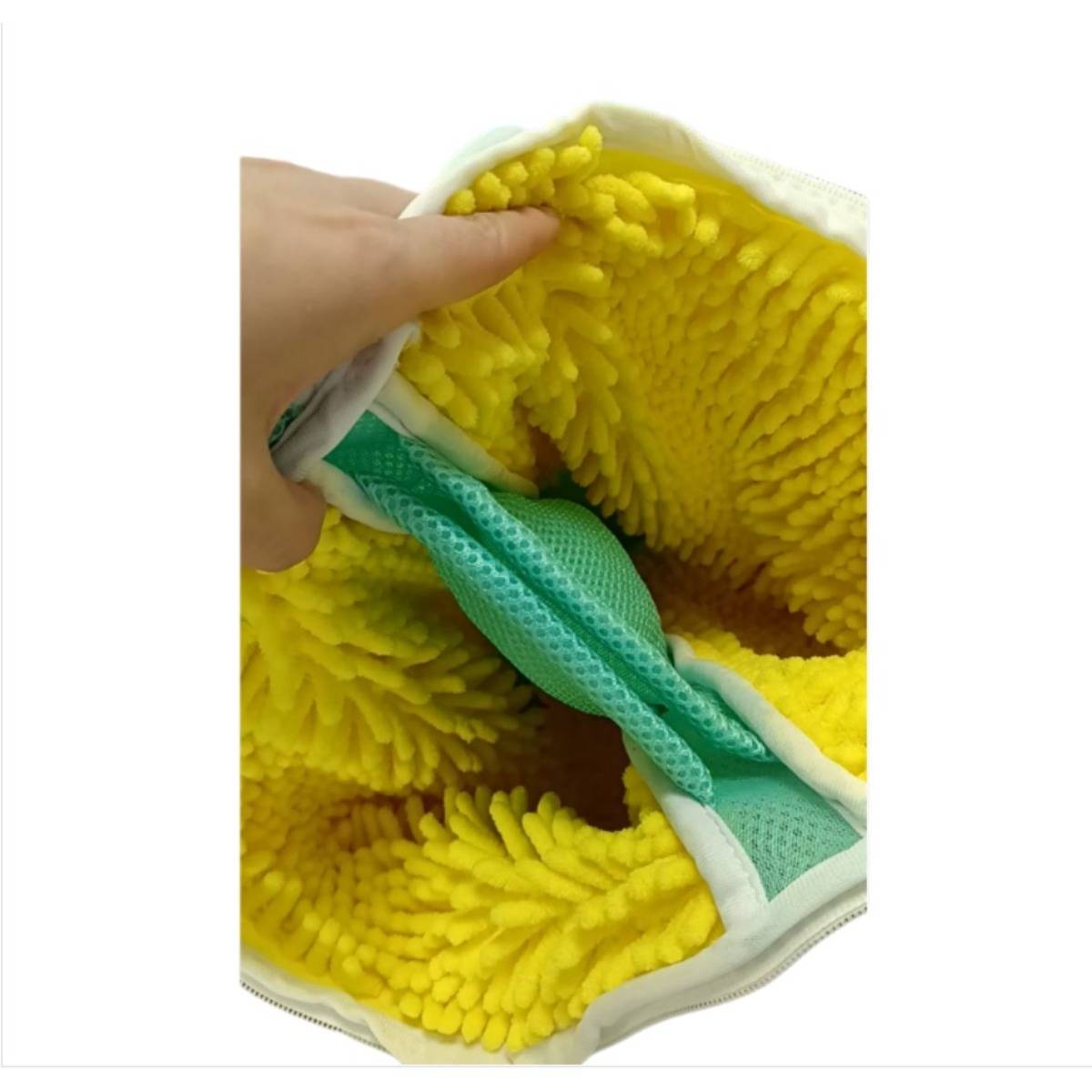 Nahaufnahme einer Hand, die einen gelben Chenille-Mikrofaser-Reinigungshandschuh offen hält und die strukturierte Innenseite und das grüne Futter zeigt.