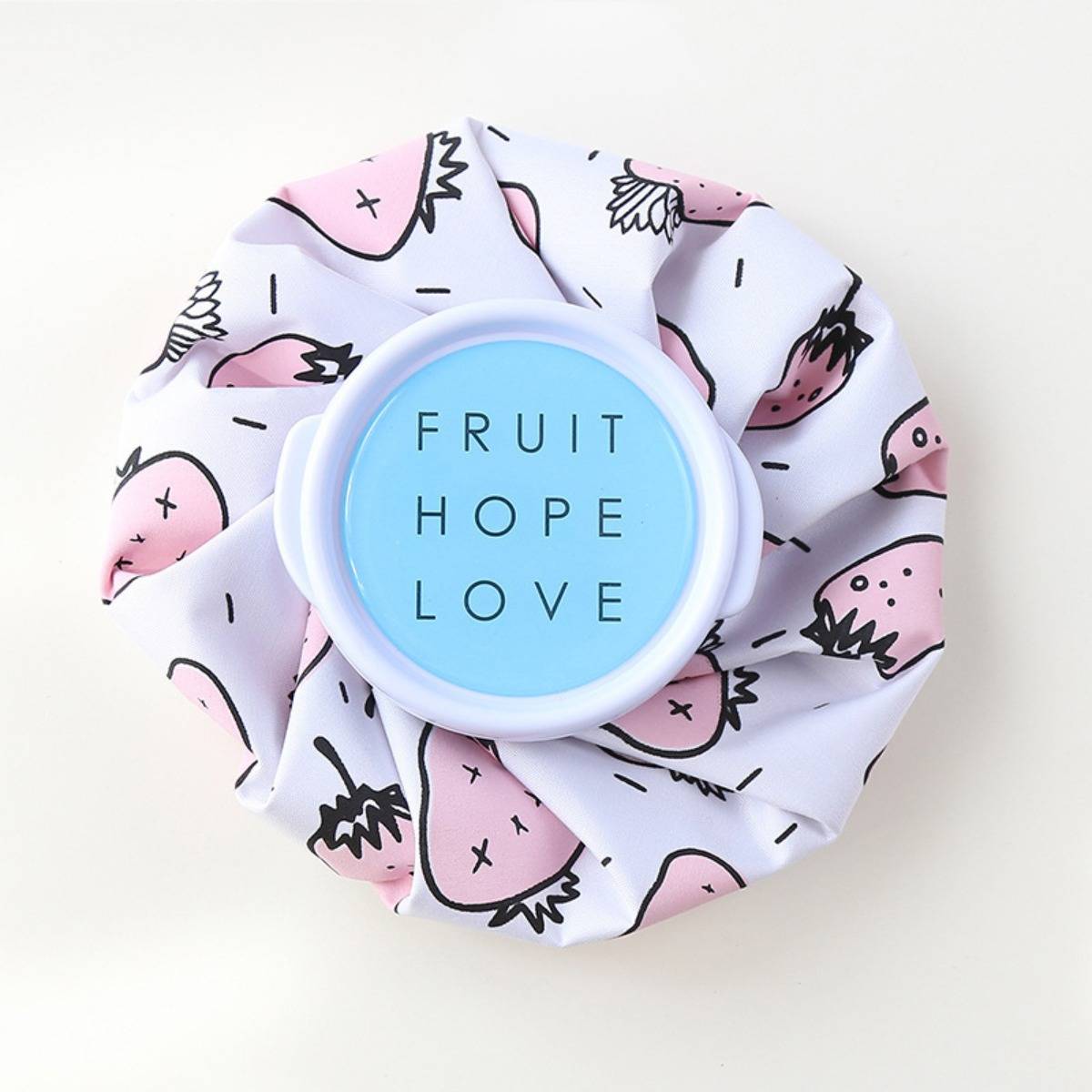 Ein Haarband aus pastellrosa Stoff mit Erdbeermuster und blauem Mittelteil mit der Aufschrift „FRUIT HOPE LOVE".