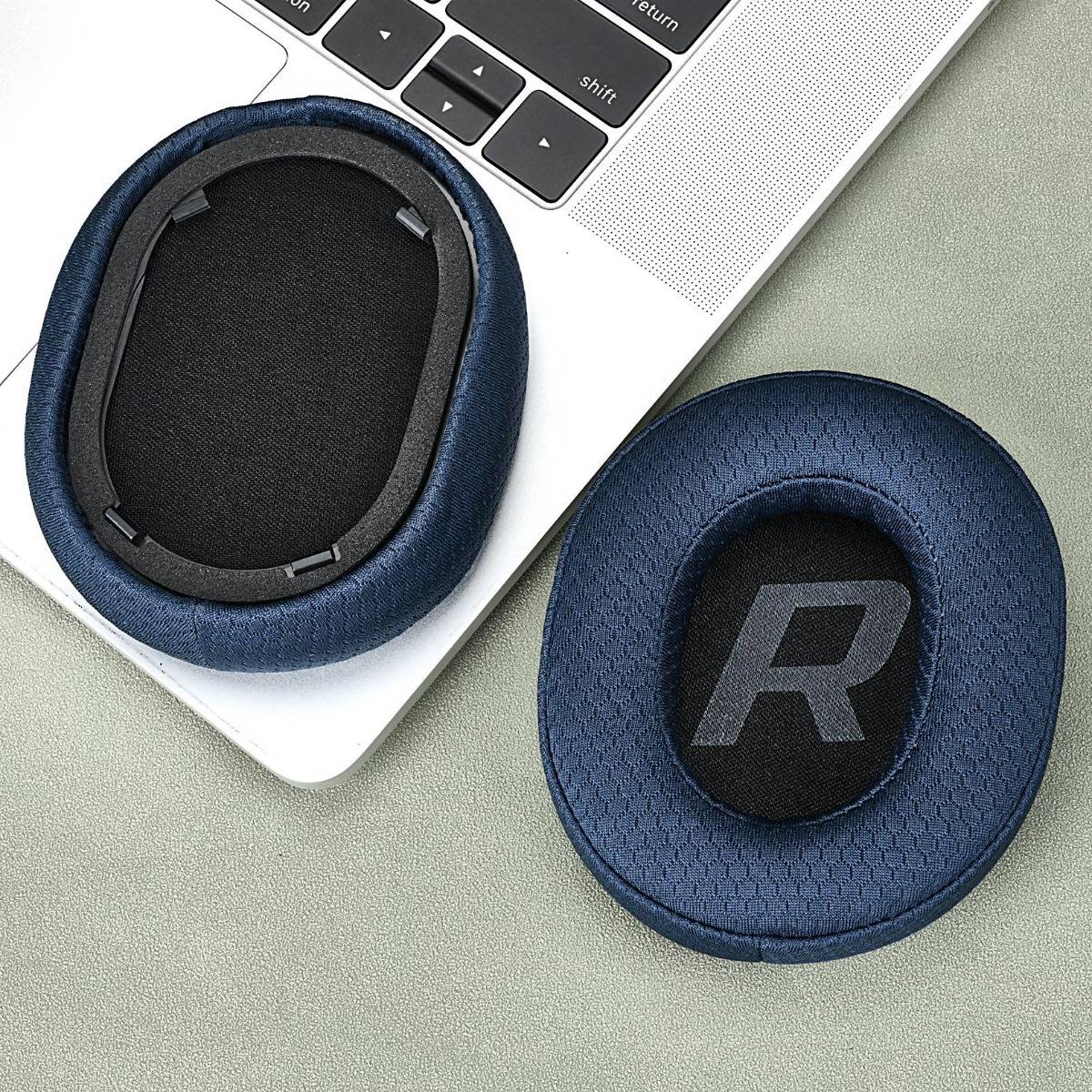 Zwei blaue Ersatz-Ohrpolster für Kopfhörer, eines zeigt den inneren Befestigungsring und eines ist mit „R" gekennzeichnet, neben einer Laptop-Tastatur.
