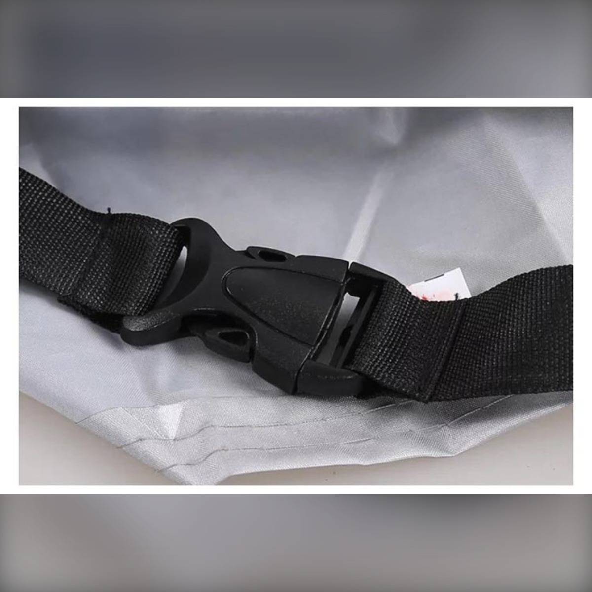 Nahaufnahme einer schwarzen Kunststoffschnalle, die einen schwarzen Gewebeband auf einer grauen Stoff-Tasche oder einem grauen Etui befestigt.