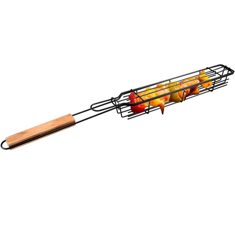 Langer Grillkorb für Grill mit Holzgriff, der Gemüsespieße und Hühnerstücke auf weißem Hintergrund hält