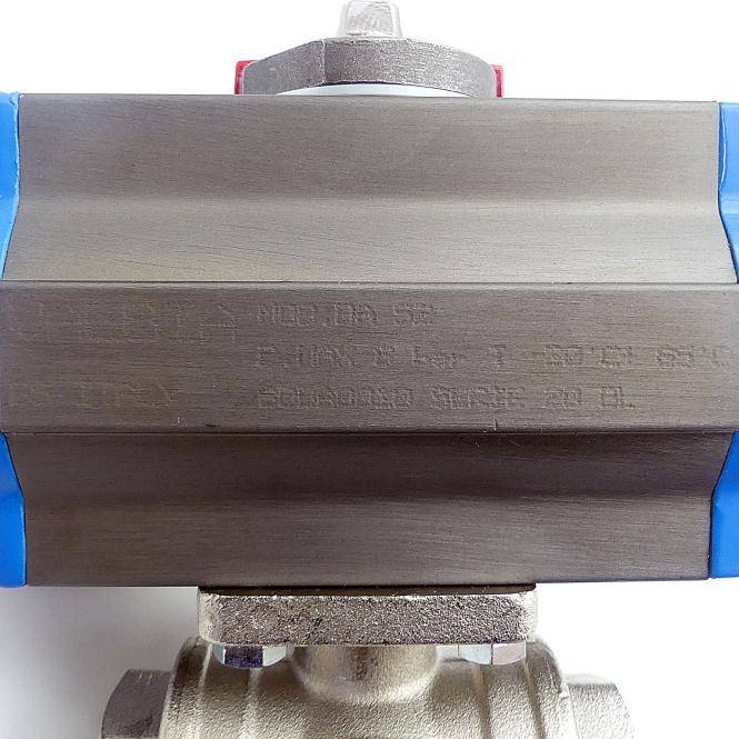 Nahaufnahme einer Metallrohrschelle oder eines Ventilgehäuses mit schwach eingravierten Markierungen, montiert zwischen blauen Seitenstücken auf weißem Hintergrund.