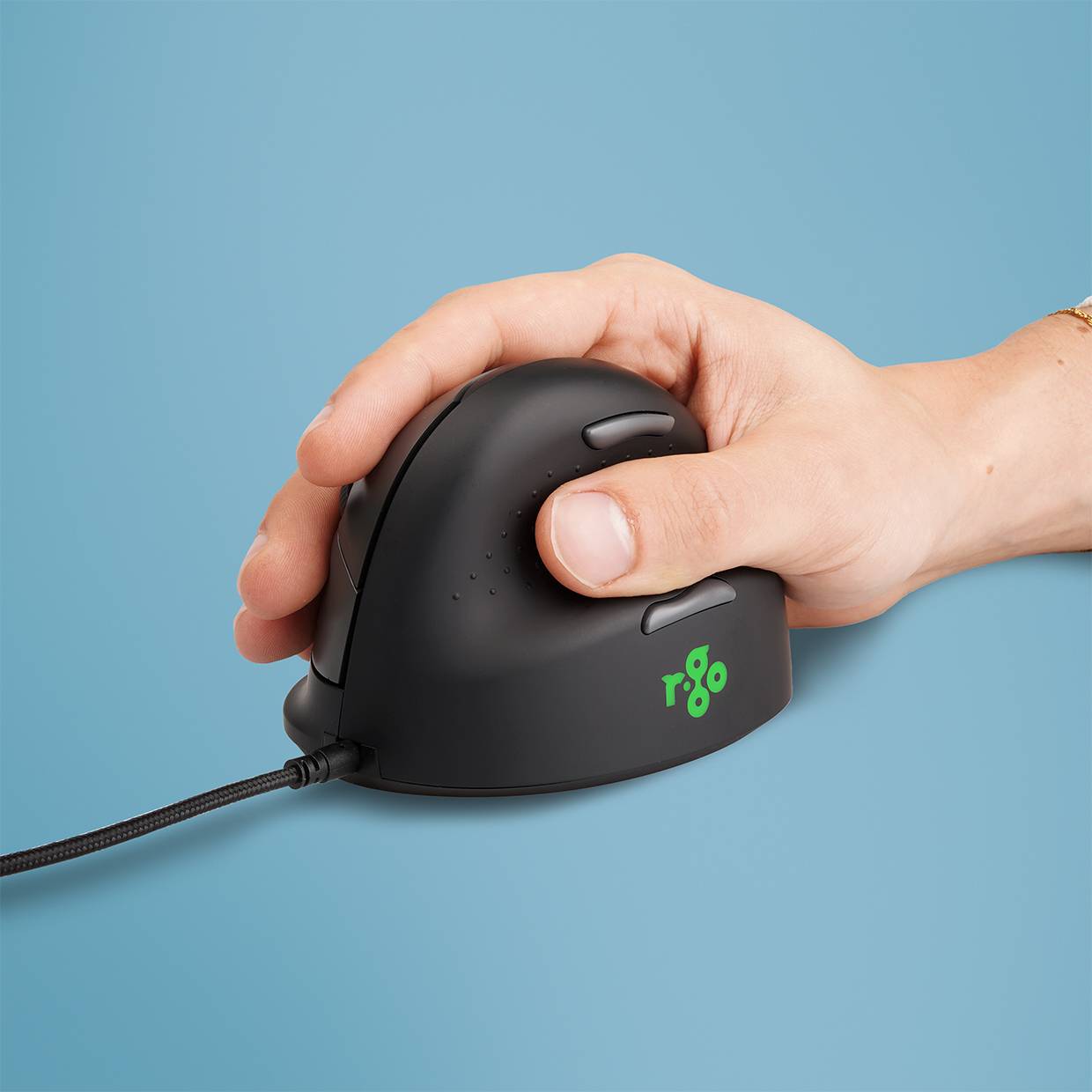 Hand greift eine schwarze ergonomische kabelgebundene Maus auf blauem Hintergrund.