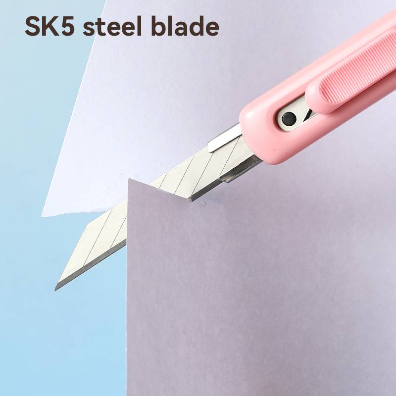 Rosa Universalmesser mit SK5-Stahlklinge schneidet violettes Papier, mit dem Text „SK5-Stahlklinge