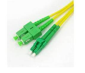 Grüne Glasfaser-Stecker an gelben Kabeln auf weißem Hintergrund.