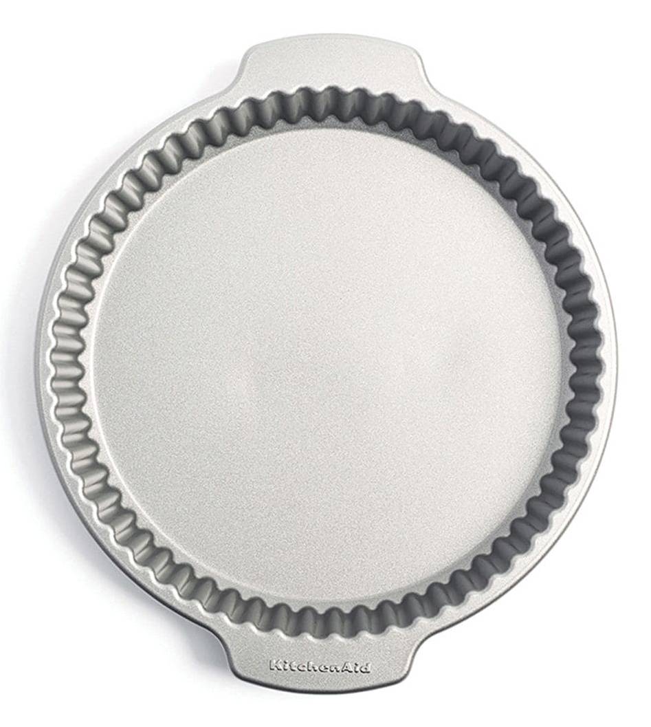 Runde Metallform zum Backen von Obstkuchen mit gerillten Seiten und abnehmbarem Boden, von oben auf weißem Hintergrund dargestellt.