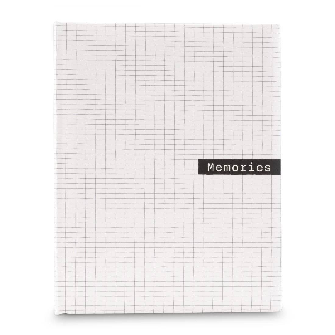 Minimalistisches Notizbuch mit weißem Millimeterpapier-Einband und schwarzem Etikett mit der Aufschrift „Memories" in der unteren rechten Ecke.
