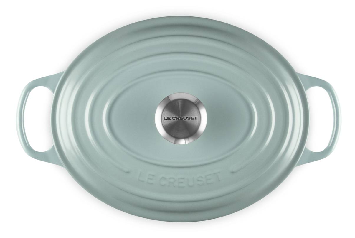 Ovales hellgrünes Le Creuset Bräter mit Deckel, zwei Griffen und Edelstahl-Deckelknopf, von oben auf weißem Hintergrund dargestellt