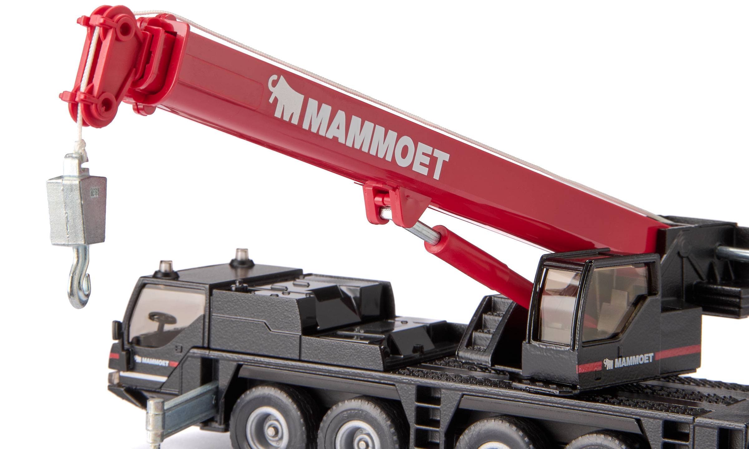 Spielzeug-Mammut-Kranwagen mit rotem Ausleger und Haken, der eine kleine Last auf weißem Hintergrund anhebt.