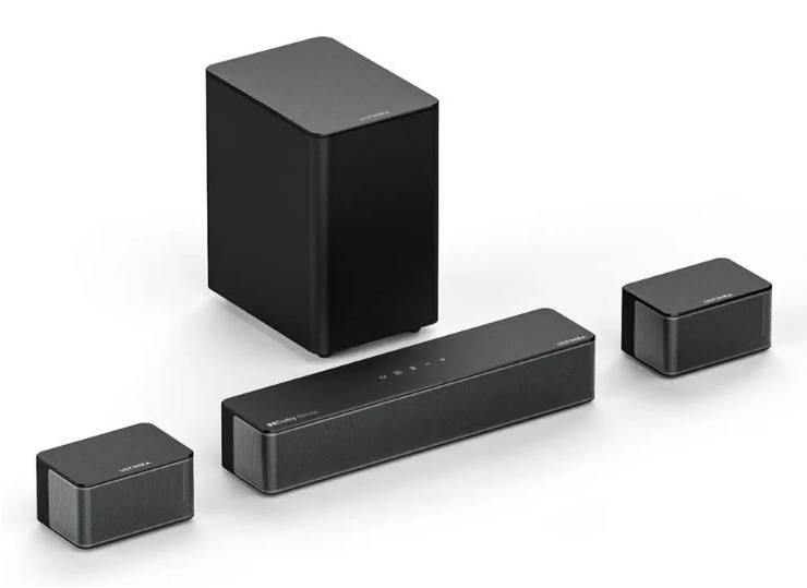 Vier schwarze Audiolautsprecher und ein Subwoofer auf weißem Hintergrund angeordnet, bestehend aus einem hohen Subwoofer, einer langen Soundbar und zwei kleinen Lautsprechern.