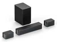 Vier schwarze rechteckige Lautsprecherkomponenten, darunter ein großer Subwoofer und drei kleinere Einheiten, angeordnet auf weißem Hintergrund.