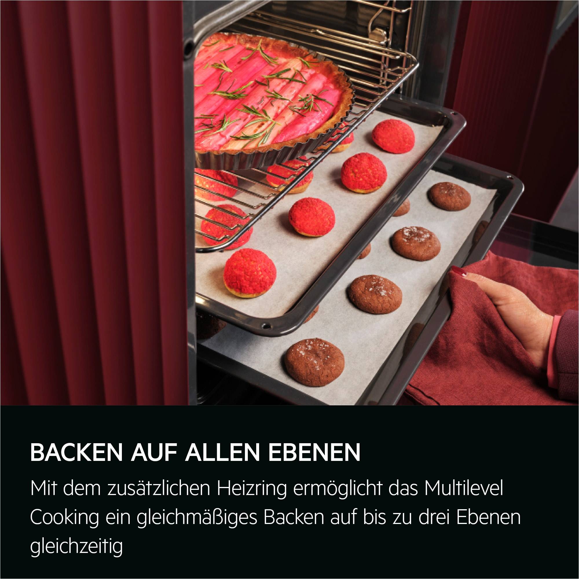 Ofeninneres mit drei Backblechen und einer Torte, zeigt mehrstufiges Kochen mit gleichmäßigem Backen auf allen Gittern.
