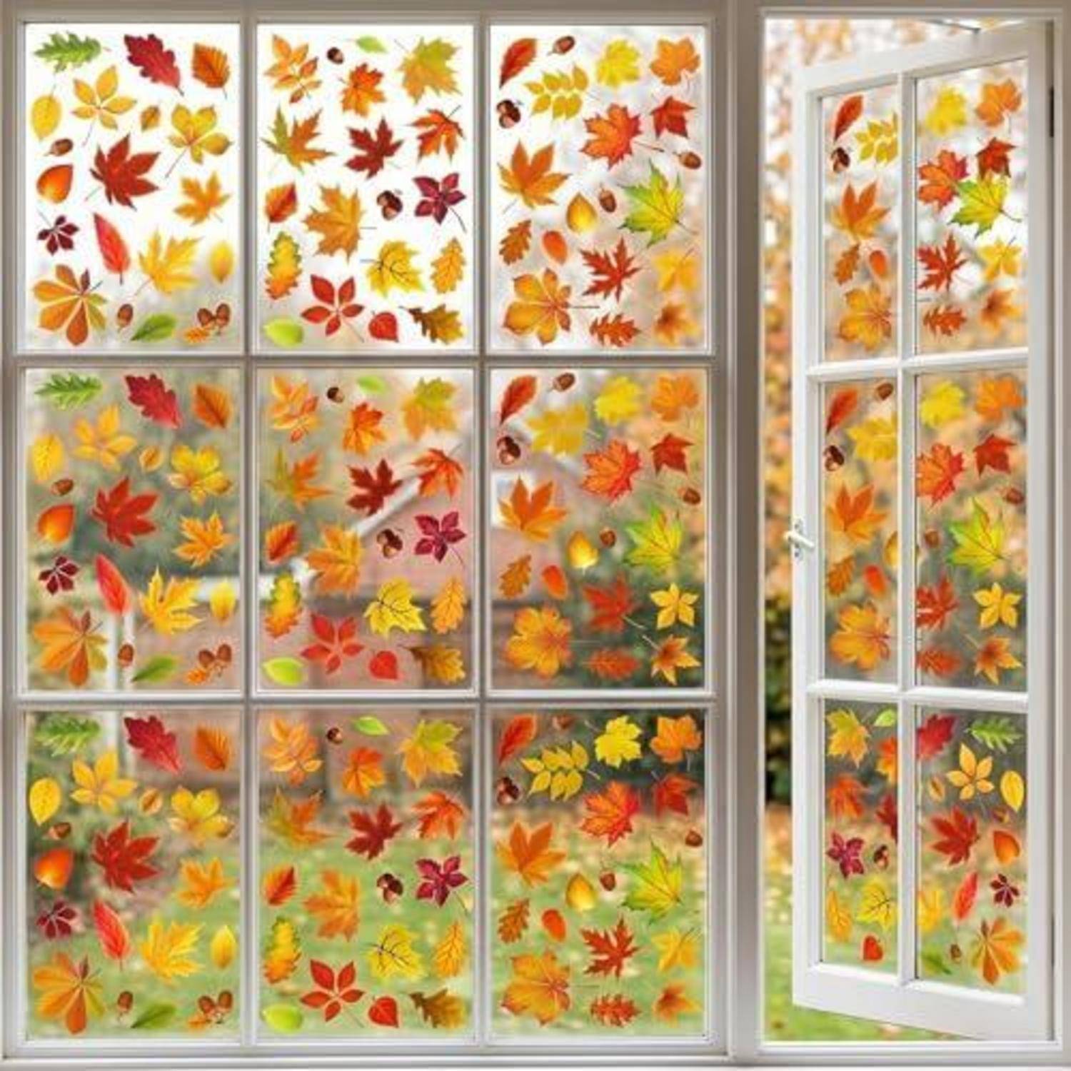 Weiß gestrichenes Fenster und offene französische Tür, dekoriert mit bunten Herbstblatt-Aufklebern, die eine herbstlich-saisonale Dekoration zeigen.