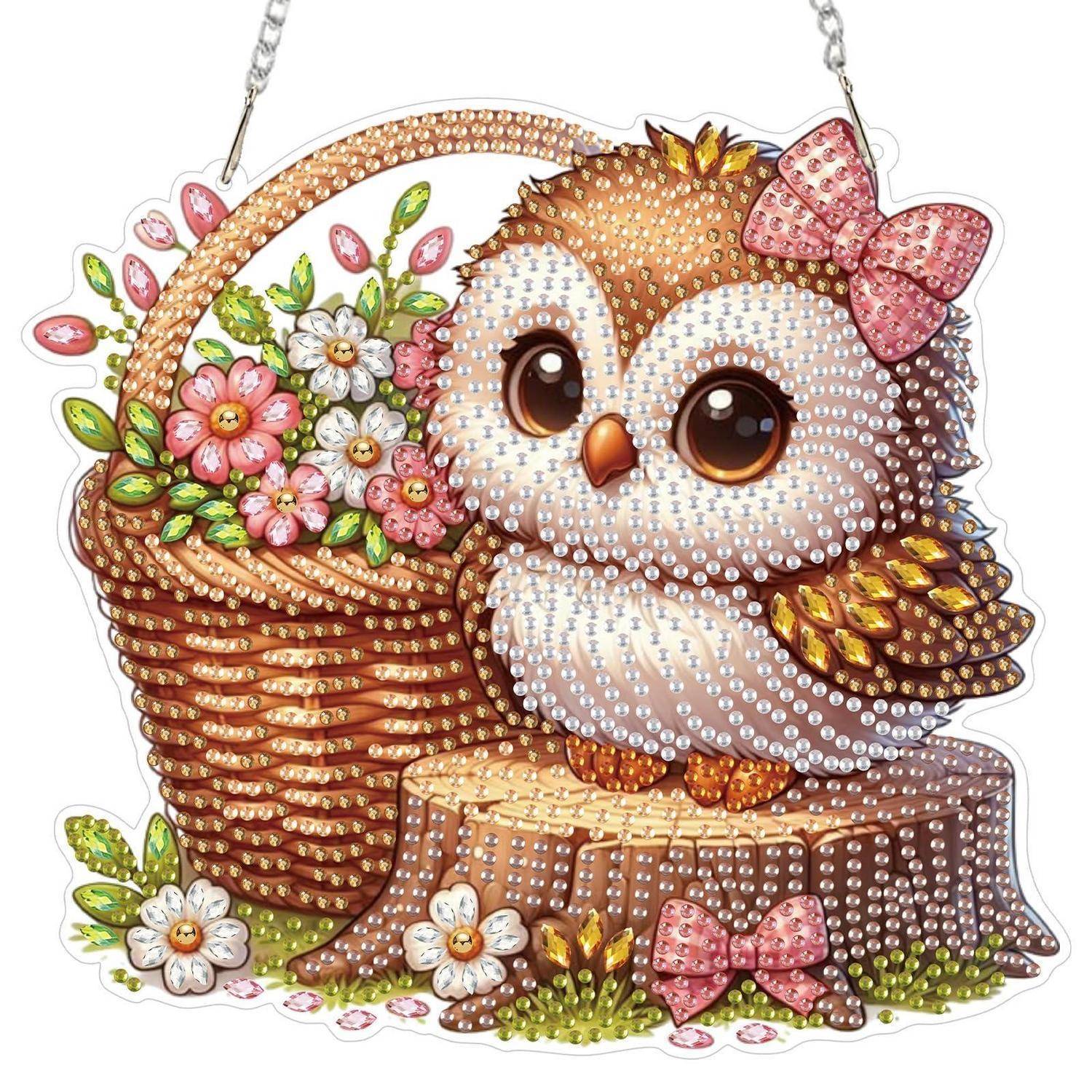 Dekorative Cartoon-Eule mit rosa Schleife sitzt auf einem Baumstumpf neben einem geflochtenen Blumenkorb, ausgeführt in perlmuttähnlichen Perlen.