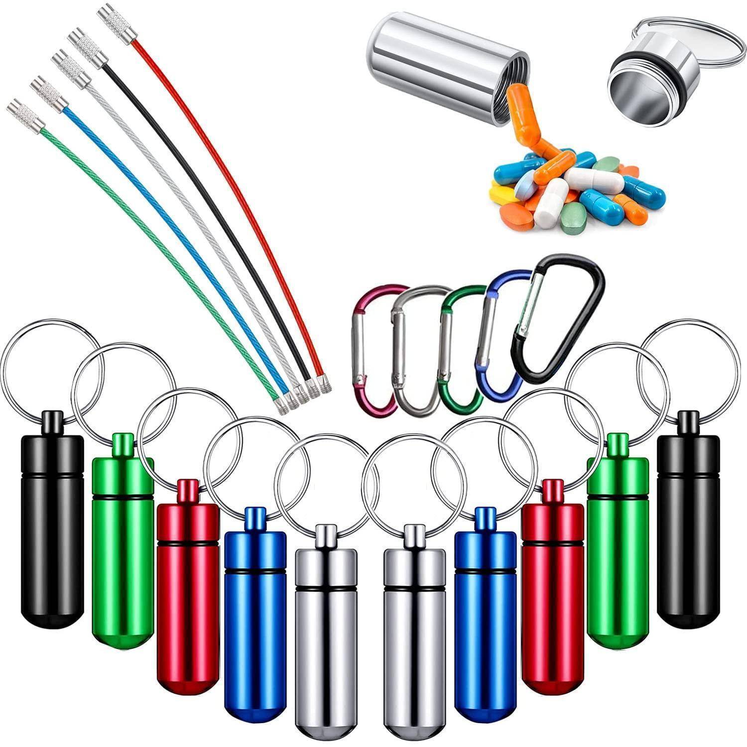 Sortierte bunte Schlüsselanhänger-Kapseln, Kabel und Karabiner in einer Produktcollage auf weißem Hintergrund angeordnet.