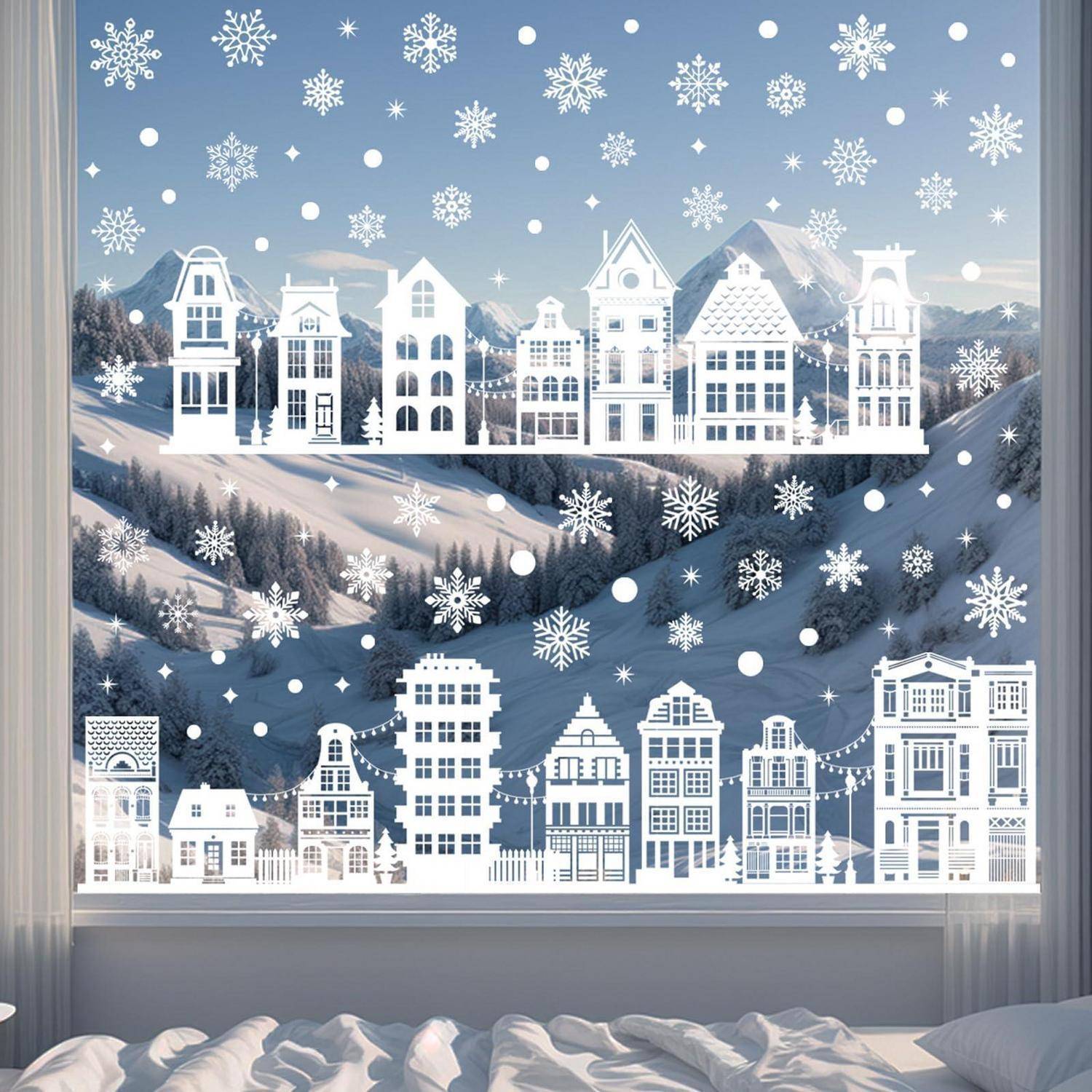 Verschneite Winterdorfszene mit weißen ausgeschnittenen Papierhäusern, Bergen und fallenden Schneeflocken, die durch ein Fenster über einem Bett zu sehen sind.