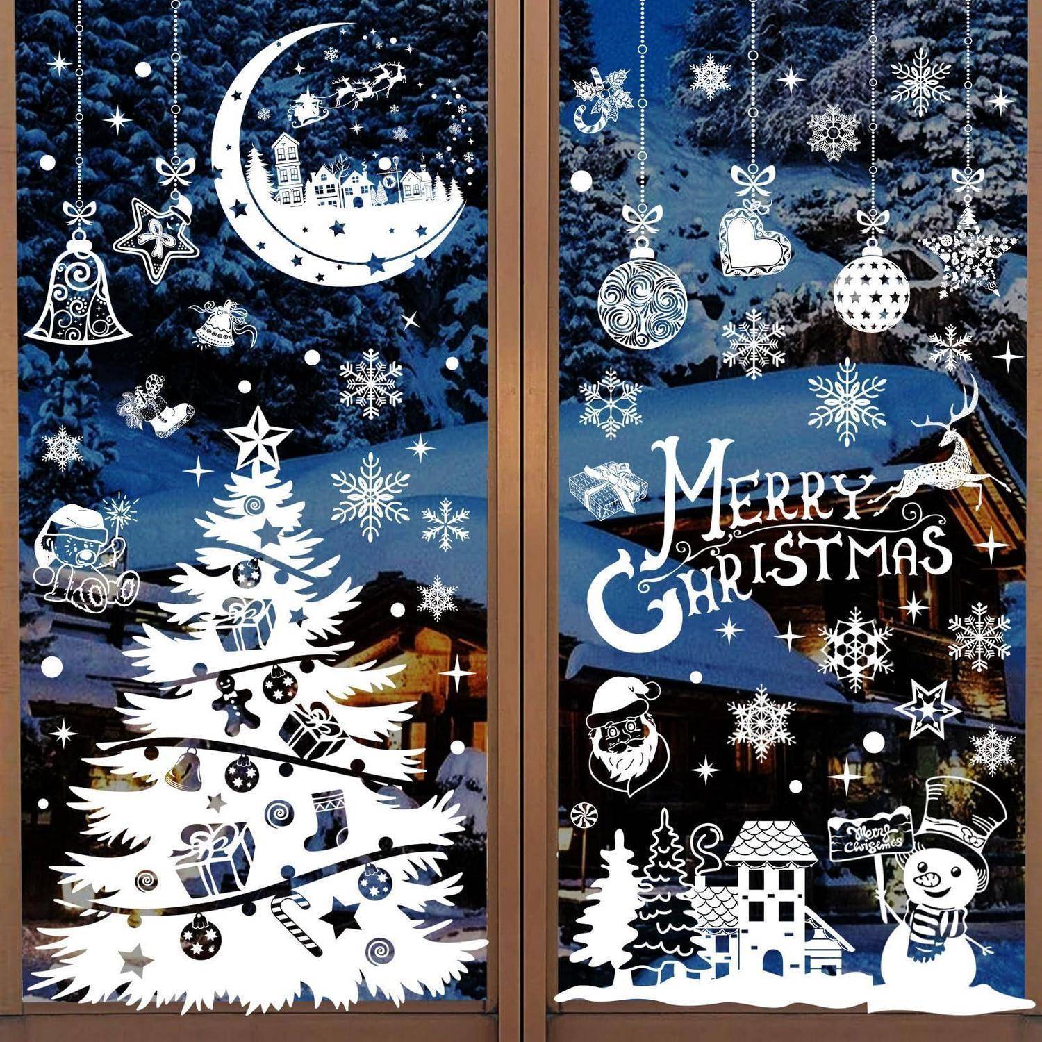 Weihnachtliches Schaufensterdisplay mit ausgeschnittenem weißem Baum, Mond, Kugeln, Schneeflocken, Text „Frohe Weihnachten