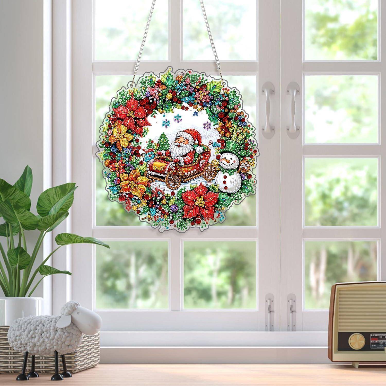 Weihnachtskranz-Dekoration mit dem Weihnachtsmann in einem Schlitten und einem Schneemann, der in einem Fenster mit einem farbenfrohen Blumenrand aufgehängt ist.