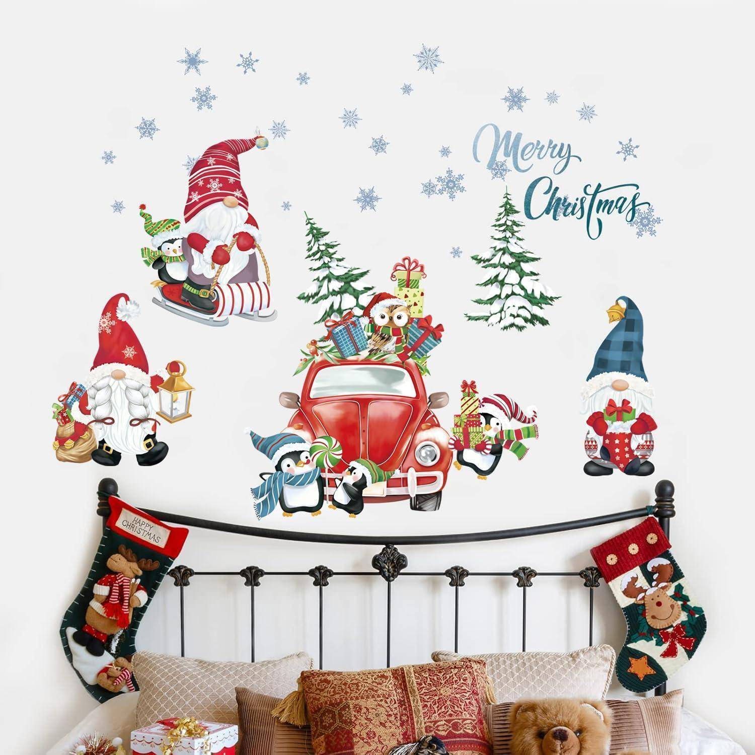 Dekorative Weihnachts-Wandaufkleber über einem Bett mit dem Weihnachtsmann, Zwergen, einem roten Auto mit Geschenken, Bäumen, Schneeflocken und dem Text „Frohe Weihnachten".