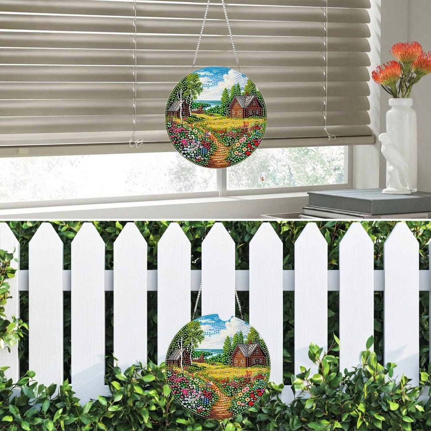 Rundes, buntes Mosaik-Sonnenfänger oder Gartenhänger mit einem Cottage und Blumenfeld, gezeigt drinnen an einem Fenster und draußen an einem weißen Lattenzaun.