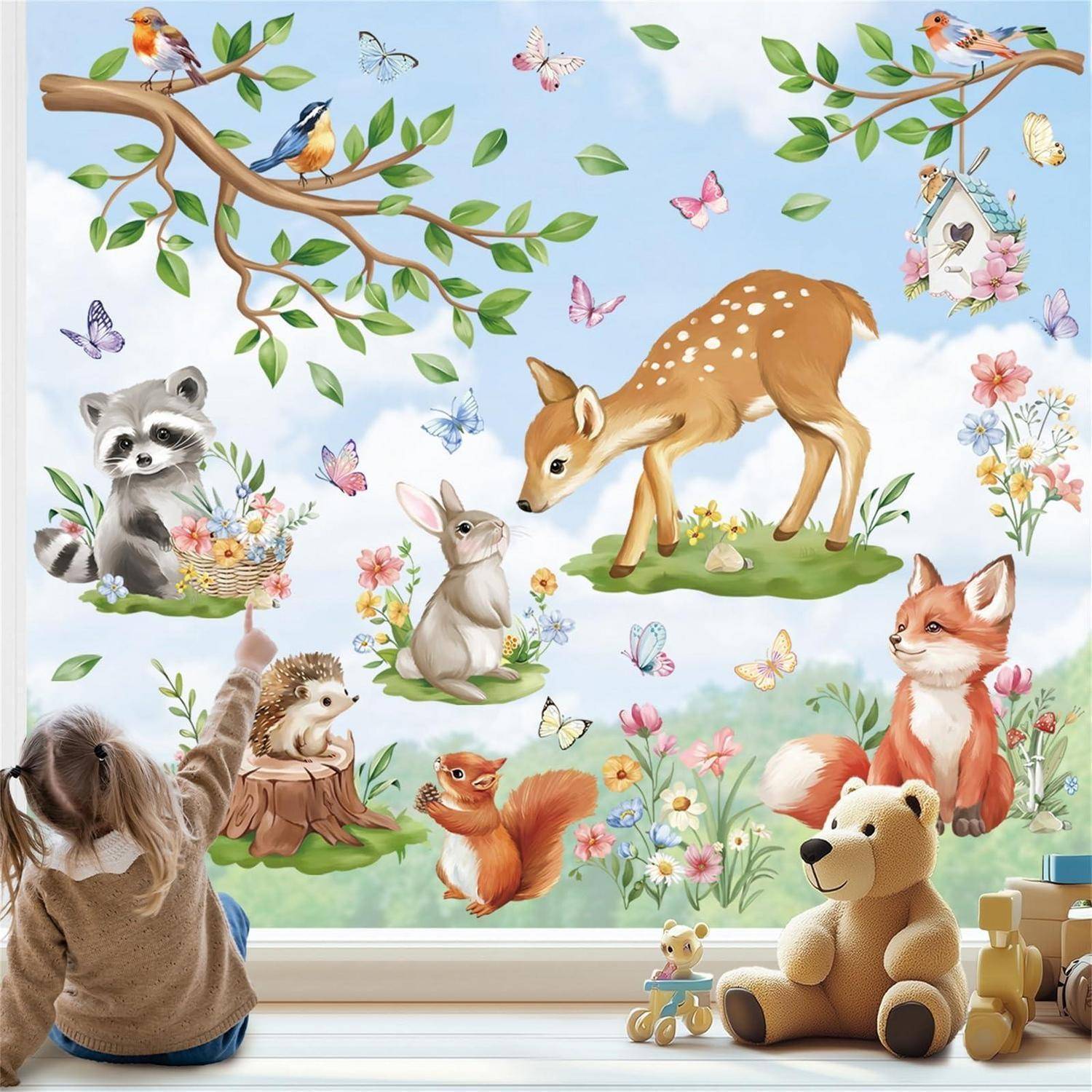 Kind betrachtet ein verspieltes Wandgemälde mit Waldtieren, Vögeln, Schmetterlingen, Blumen und Spielzeugtieren in einer Kinderzimmerszenerie.