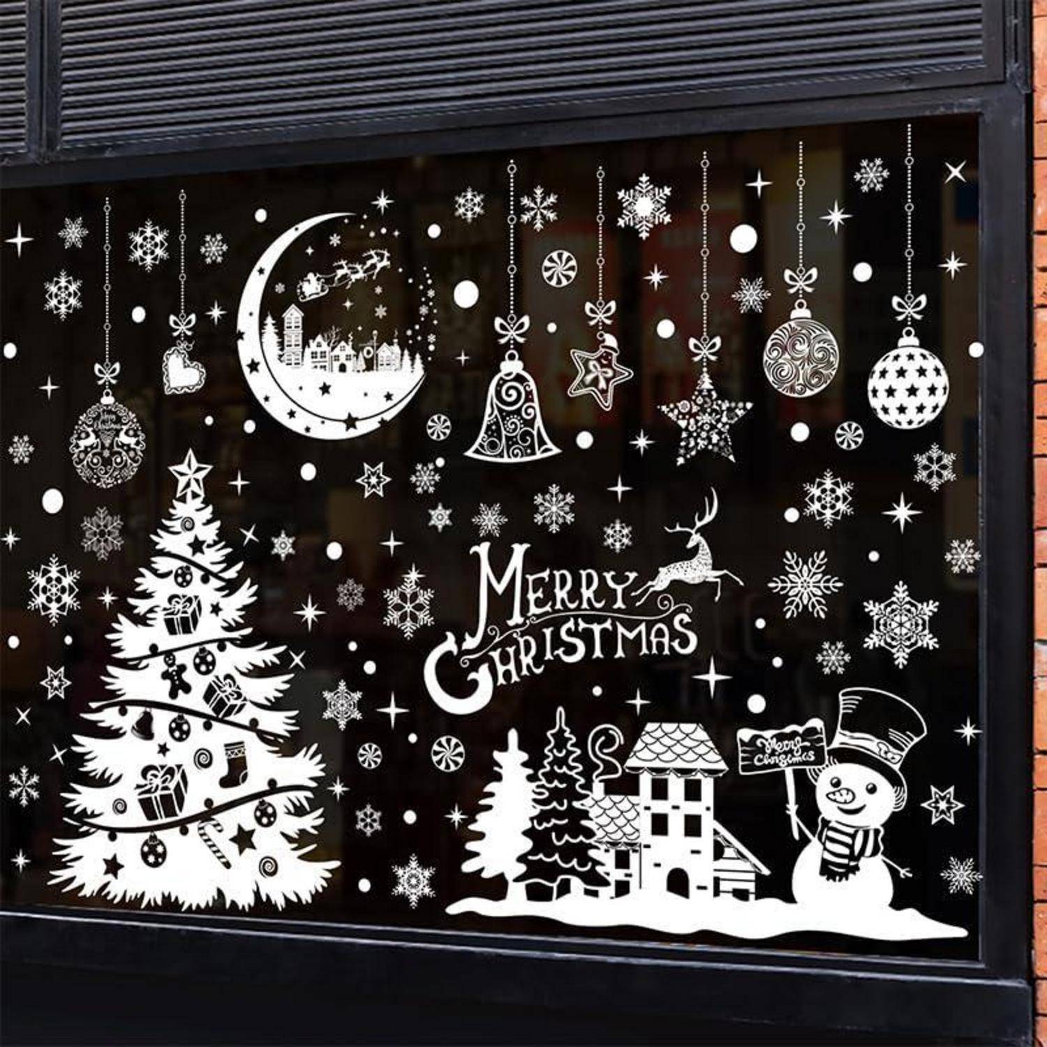 Schwarz-weiße Weihnachtsschaufenster-Dekoration mit dem Text „Frohe Weihnachten", dekoriertem Baum, Schneemann, Haus, Christbaumkugeln, Schneeflocken und Mondszene.