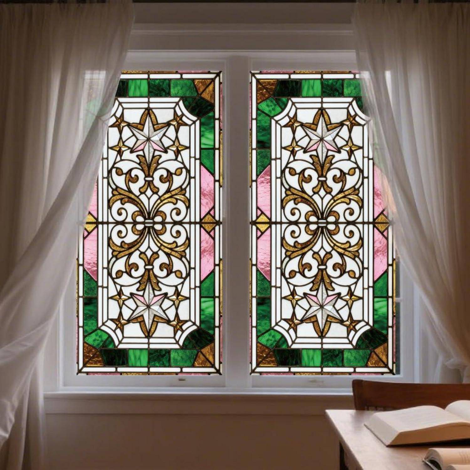 Zwei ornamentale Buntglasfenster mit grünen, rosa und weißen geometrischen Blumenmustern, umrahmt von transparenten Vorhängen über einem Schreibtisch mit einem aufgeschlagenen Buch.