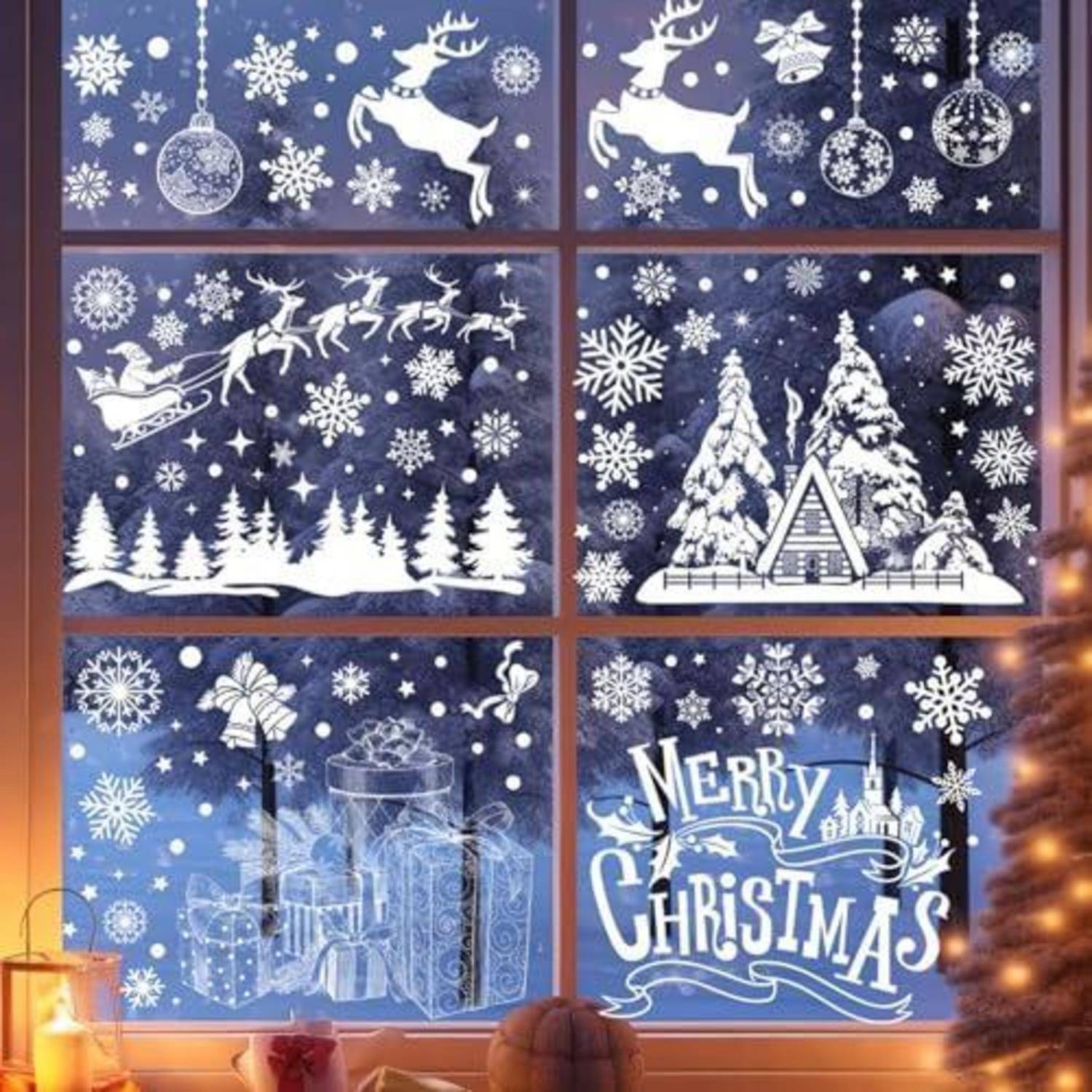 Weihnachtliche Fensterausstellung mit sechs blau-weißen Weihnachtsszenen: Rentiere, Weihnachtsmannschlitten, schneebedeckte Bäume, Geschenkboxen und „FROHE WEIHNACHTEN"-Text.