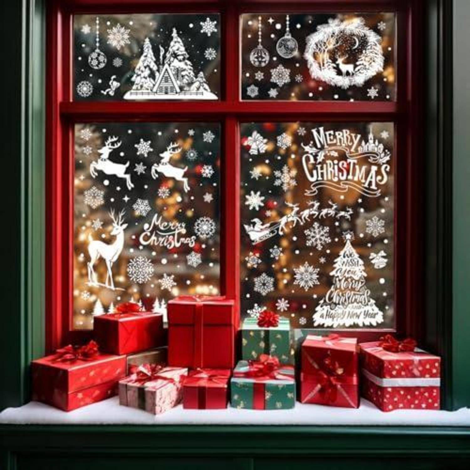 Weihnachtliches Schaufenster mit weißen Schneeflocken, Rentieren und „Frohe Weihnachten"-Beschriftung, umrahmt von rotem Rahmen und Geschenkboxen auf der Fensterbank.