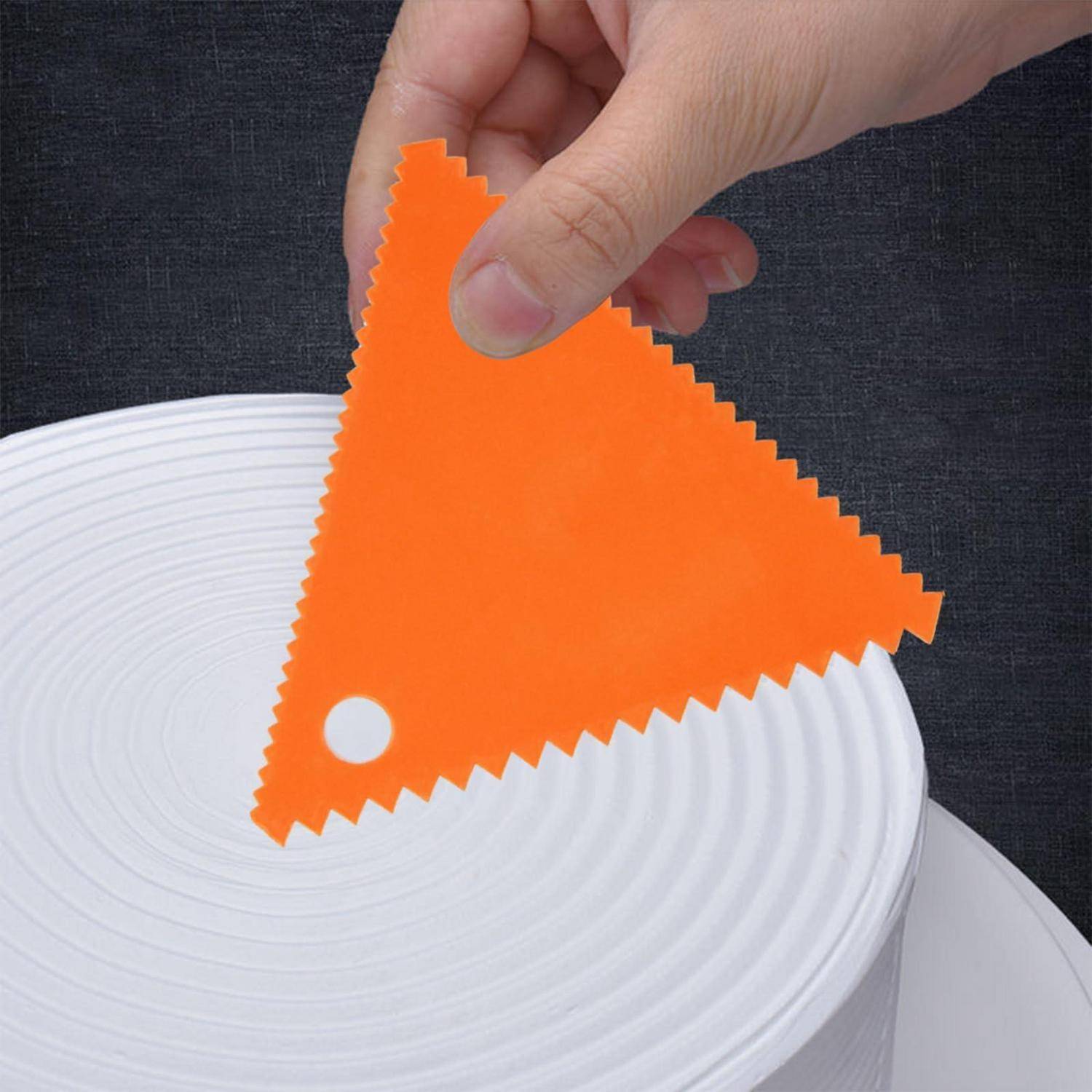 Hand, die ein oranges dreieckiges Stoffmuster über einem weißen strukturierten Teller auf dunklem Hintergrund hält.