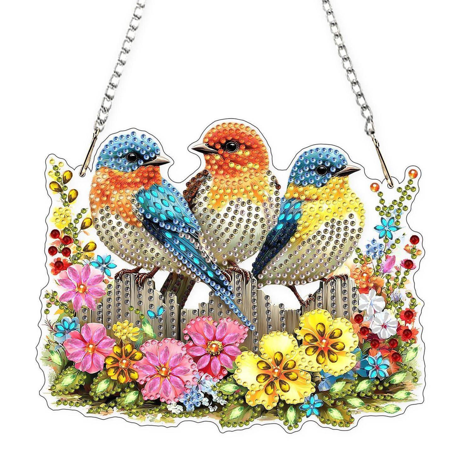 Dekorative Vogel-Wanddeko mit drei bunten Strass-Vögeln, die über leuchtenden Blüten und Blättern thronen, aufgehängt an Silberketten.