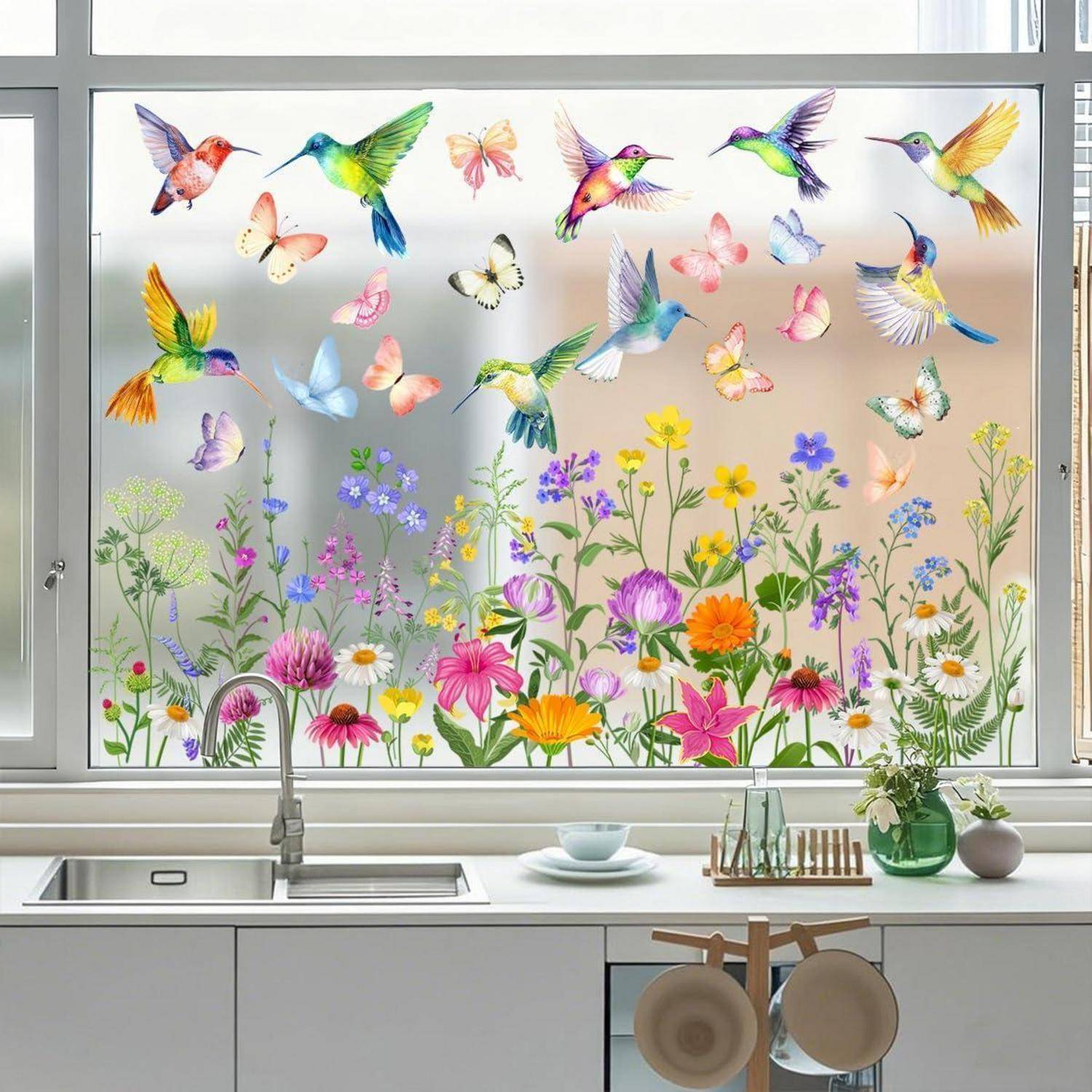 Küchenfenster mit bunten Kolibris und Schmetterlingen über Wildblumen, die einen dekorativen Gartenstil-Ausblick über dem Spülbecken schaffen.