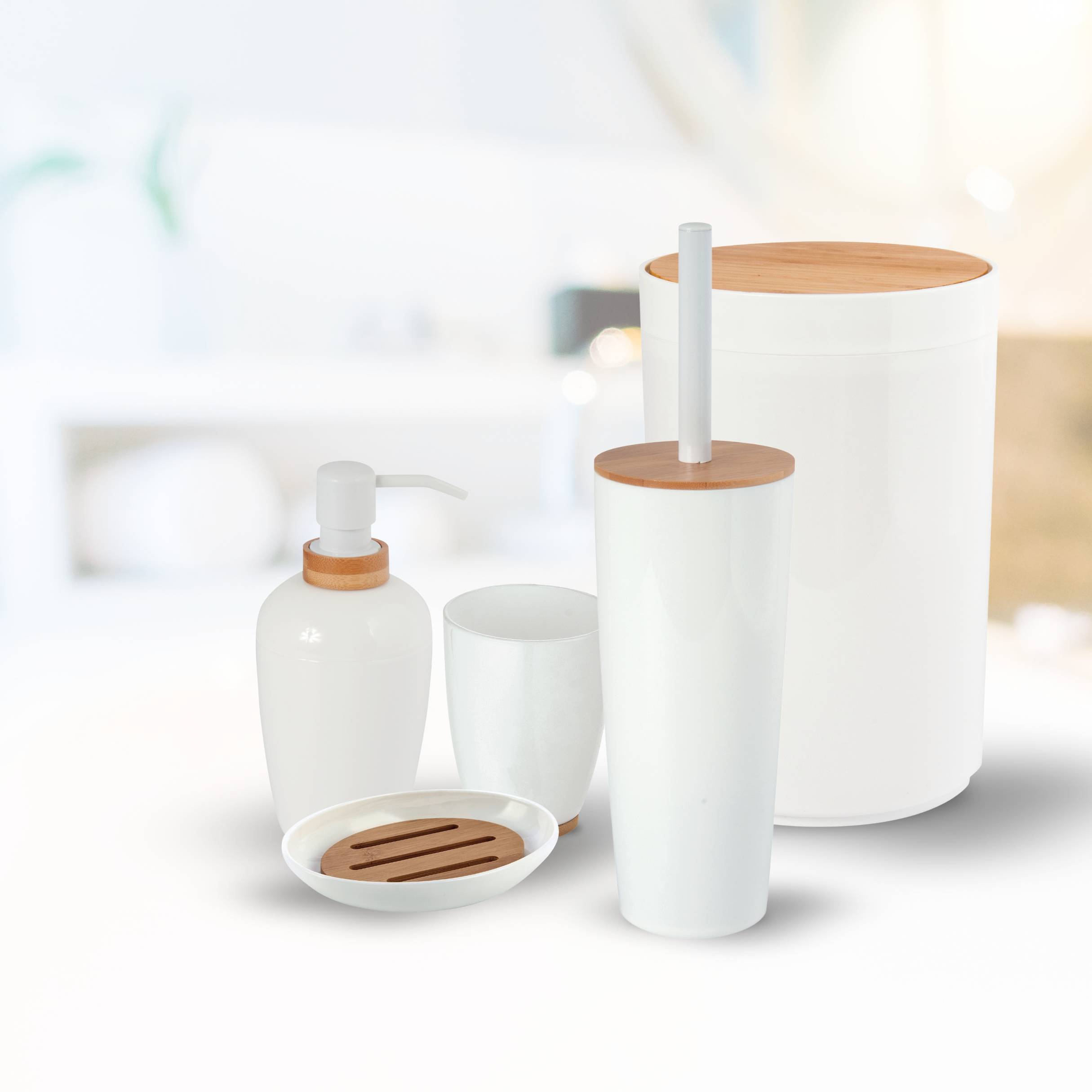 Weiße Badezimmeraccessoire-Set einschließlich Seifenspender, Becher, Trinkglas, Tablett und Behälter mit Deckel mit Holzakzenten auf hellem Hintergrund.